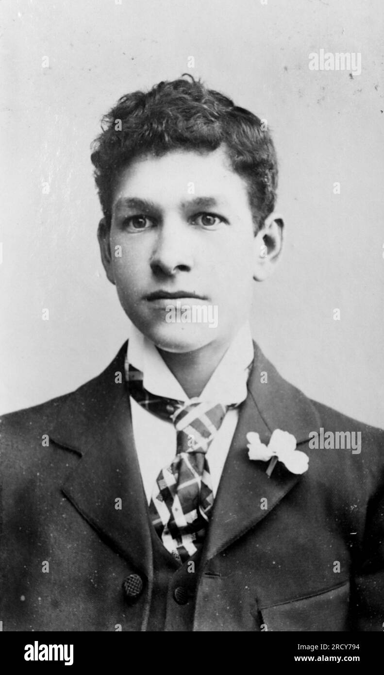 Portrait tête et épaule d'un jeune homme portant une cravate et ayant une fleur au revers. Photographie originale non attribuée. D'une collection de photographies victoriennes carte de visite, datées des années 1890 Carte de visite est un terme français connu en anglais sous le nom de « Visiting card ». Ils avaient généralement un tirage photographique albumen d'environ 54x89mm monté sur une carte légèrement plus grande. Dans certains cas, les ravages du temps ont fait leurs ravages. Banque D'Images