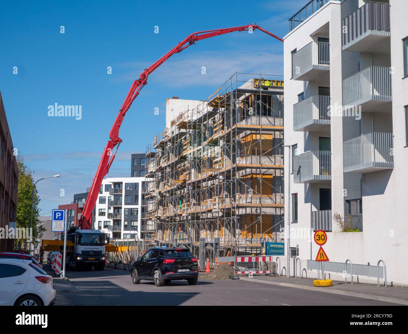 Un camion-pompe à béton livre du béton sur un chantier de construction à Reykjavik, en Islande. Appartements neufs. Le réaménagement et les nouveaux bâtiments peuvent être vus tous Banque D'Images