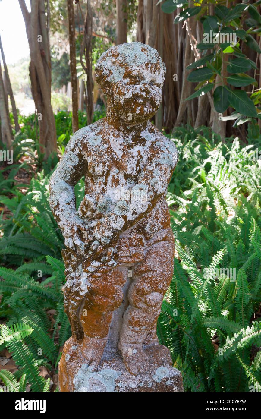 Érosion d'une statue de pierre de garçon dans le jardin du John and Mable Ringling Museum, Sarasota, Floride. Banque D'Images