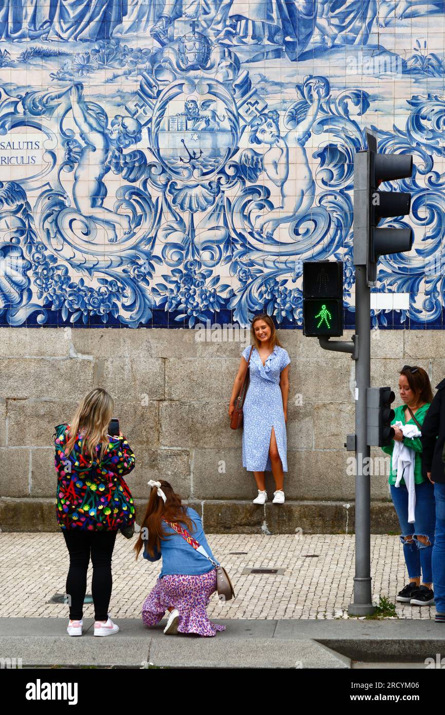 Une touriste a sa photo prise devant les azulejos / carreaux de céramique sur le mur latéral de l'église Igreja do Carmo, Porto / Porto, Portugal Banque D'Images