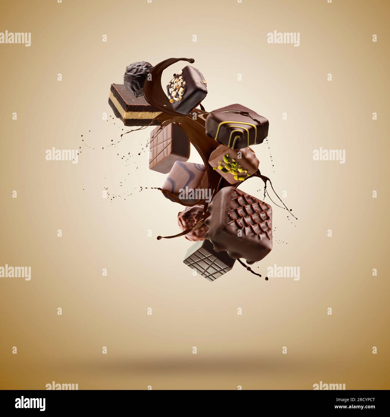 Pralines au chocolat assorties flottant avec une éclaboussure de chocolat fondu sur fond brun Banque D'Images