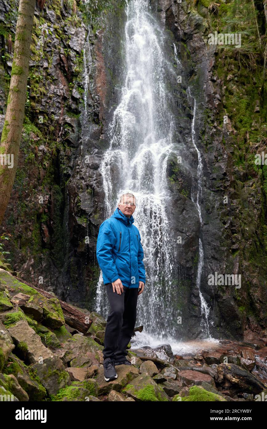 Attraction touristique de l'Allemagne - chutes de Burgbach Waterfall près de Schapbach, Forêt Noire, Bade-Wurtemberg, Allemagne. Homme randonneur dans une chemise bleue Banque D'Images