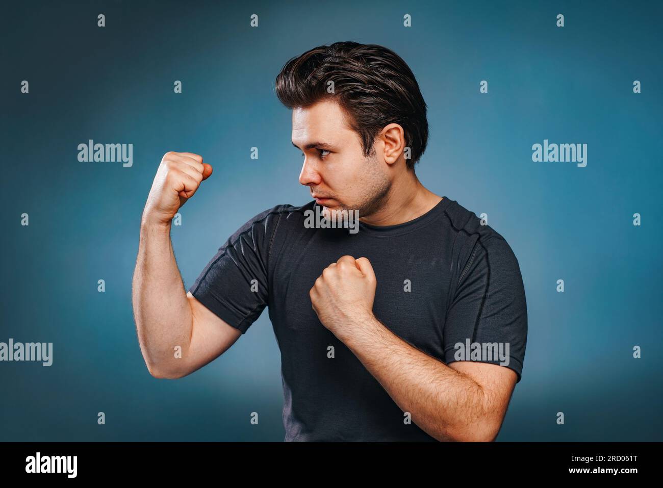 Jeune homme brune combattant sur fond bleu Banque D'Images