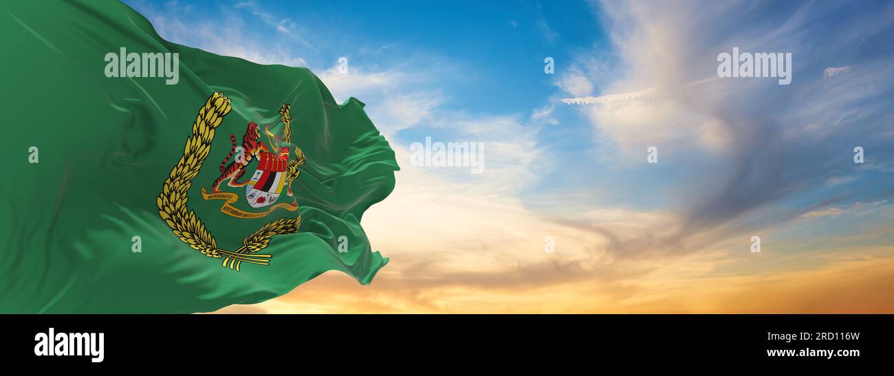 Drapeau officiel du Standard de la Raja Permaisuri Agong Malaisie sur fond ciel nuageux au coucher du soleil, vue panoramique. Voyage malaisien et patrimoine conce Banque D'Images