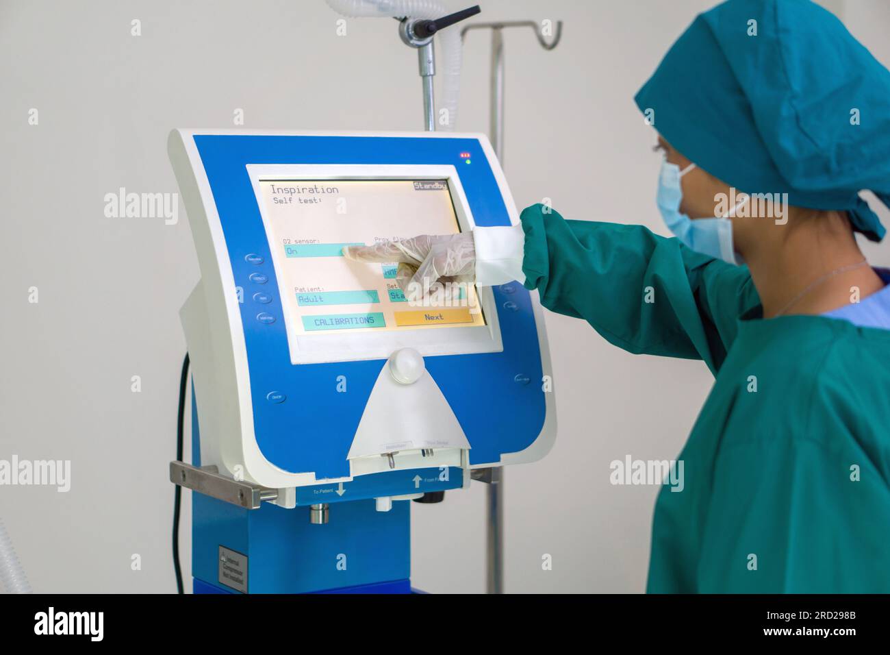 Un chirurgien inébranlable, vêtu d'une tenue chirurgicale stérile, utilise de manière experte un dispositif électronique avancé au milieu de la sérénité high-tech d'un opérat Banque D'Images