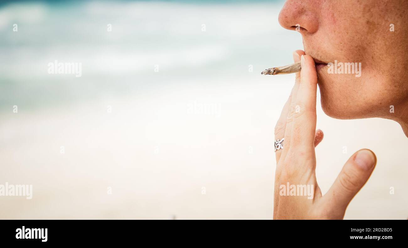 femme fumant un joint sur la plage Banque D'Images