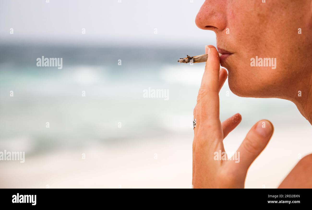 femme fumant un joint sur la plage Banque D'Images