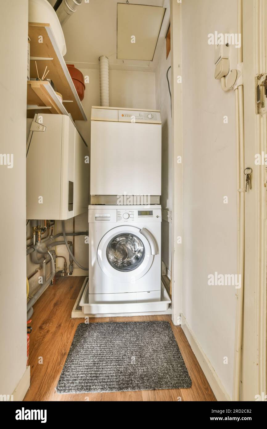 une petite buanderie avec lave-linge et sèche-linge dans le coin à côté de  la porte qui est ouverte Photo Stock - Alamy
