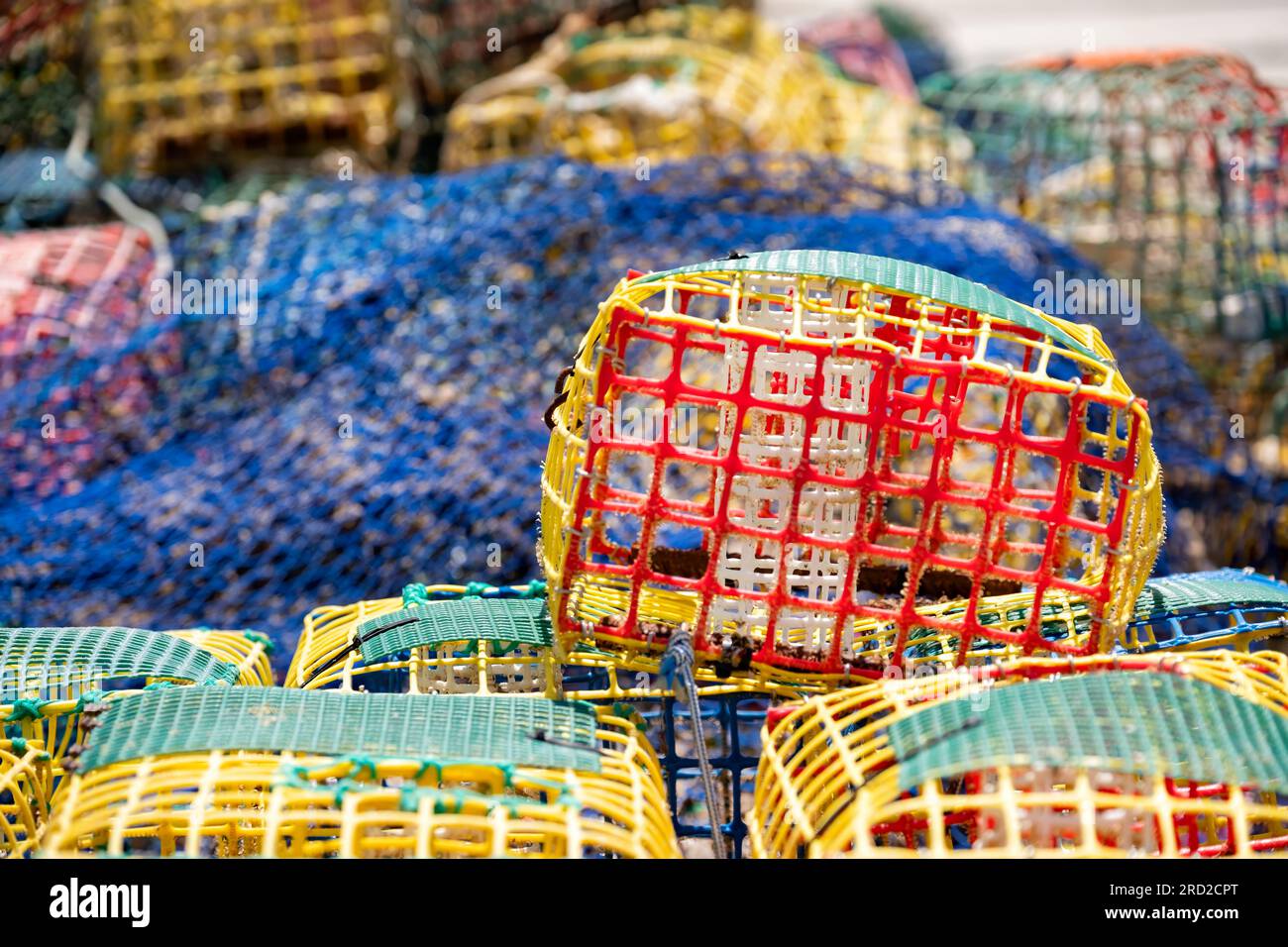Une pile de pots ou de paniers de homard et de crabe en plastique colorés laissés à sécher par un pêcheur sur le quai du vieux port, Estepona, Espagne Banque D'Images