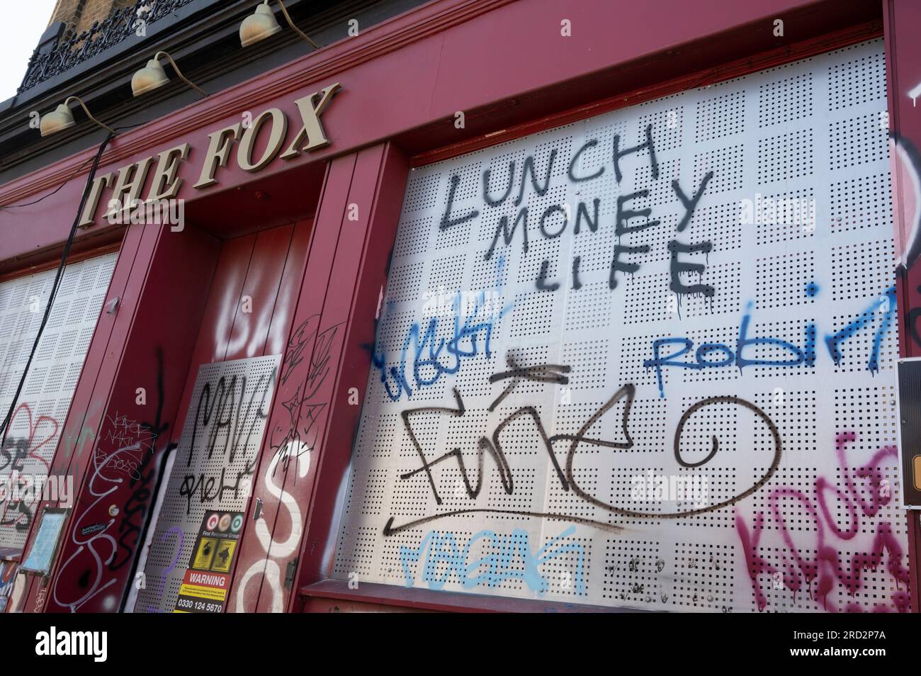 Hackney, Londres. Kingsland Road. Le Fox, autrefois un pub populaire, a embarqué avec grafitti sur les volets Banque D'Images