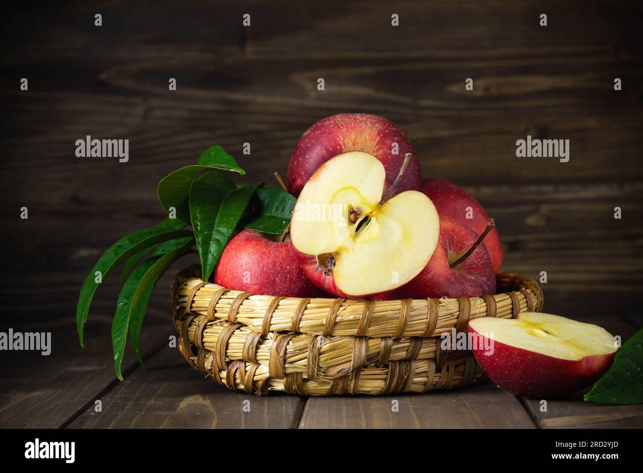 Pommes rouges saines rustiques sur un panier sur fond en bois Banque D'Images