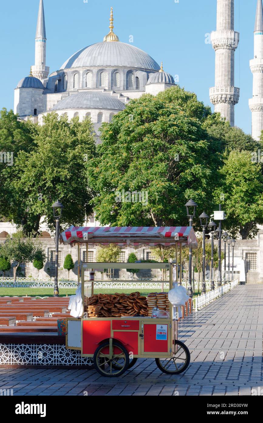 Mosquée du Sultan Ahmed alias Mosquée Bleue à Sultanahmet, Istanbul, Turquie. Plus des sièges et un chariot distributeur rouge avec des Simits aka bagels turcs Banque D'Images