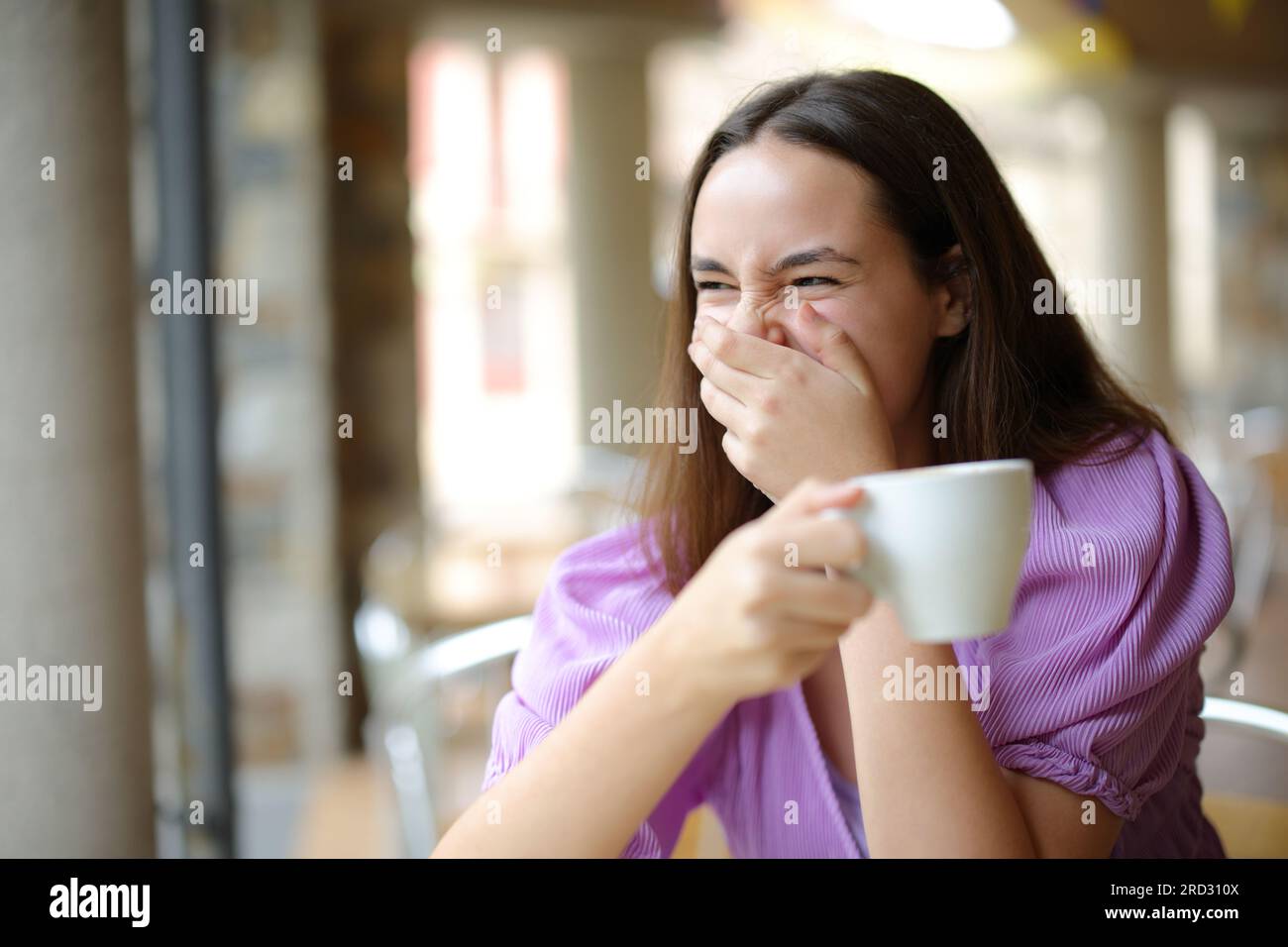 Femme heureuse buvant du café riant fort dans une terrasse de bar Banque D'Images
