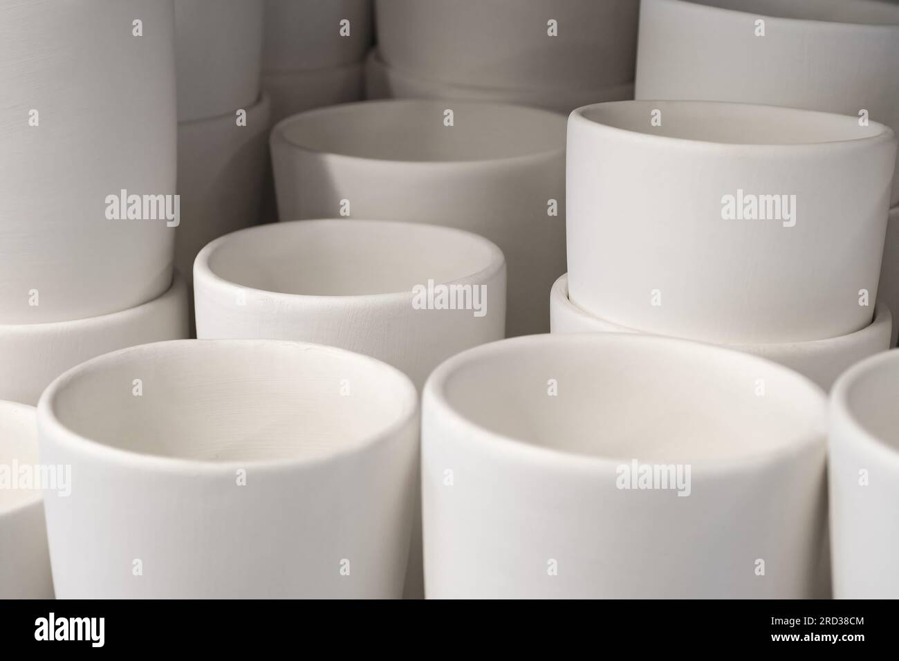 Grand groupe de tasses simples en porcelaine blanche non peinte, fond abstrait Banque D'Images