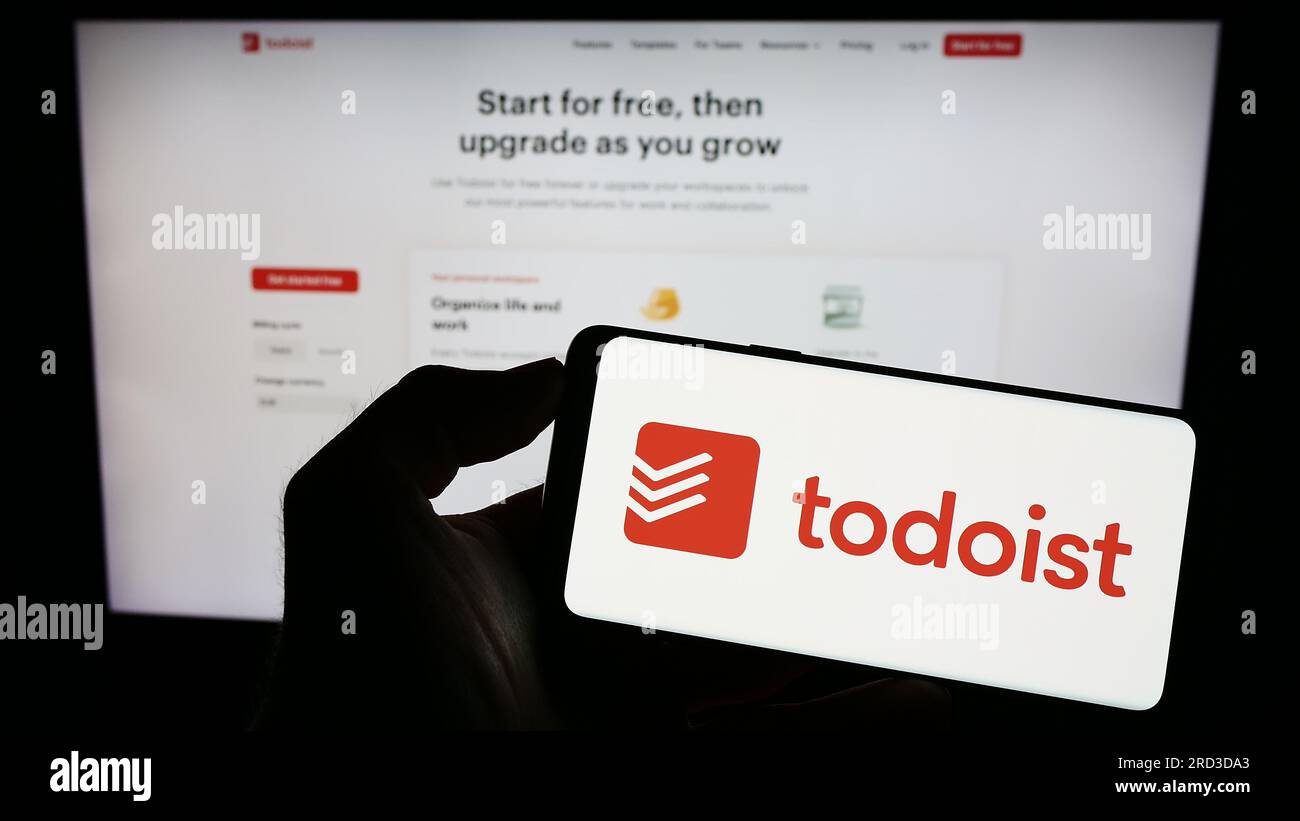 Personne tenant le téléphone portable avec le logo de la société américaine de gestion des tâches Todoist (Doist Inc.) sur l'écran en face de la page Web. Concentrez-vous sur l'affichage du téléphone. Banque D'Images