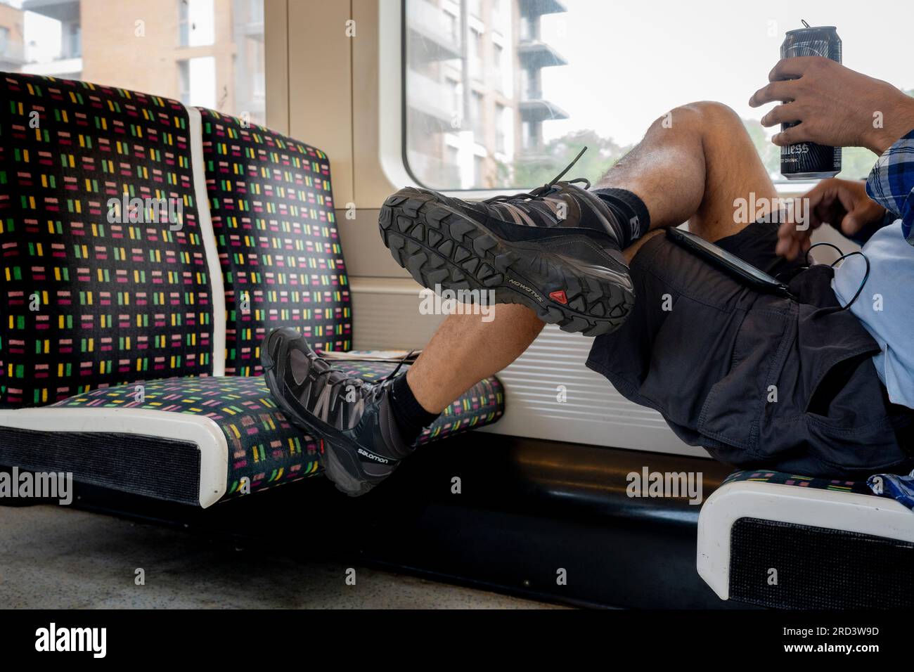 Un passager en tube est assis avec un coffre reposant sur le siège en tissu d'un train voyageant sur la Metropolitan Line dans le centre de Londres , le 18 juillet 2023, à Londres, Angleterre. Banque D'Images