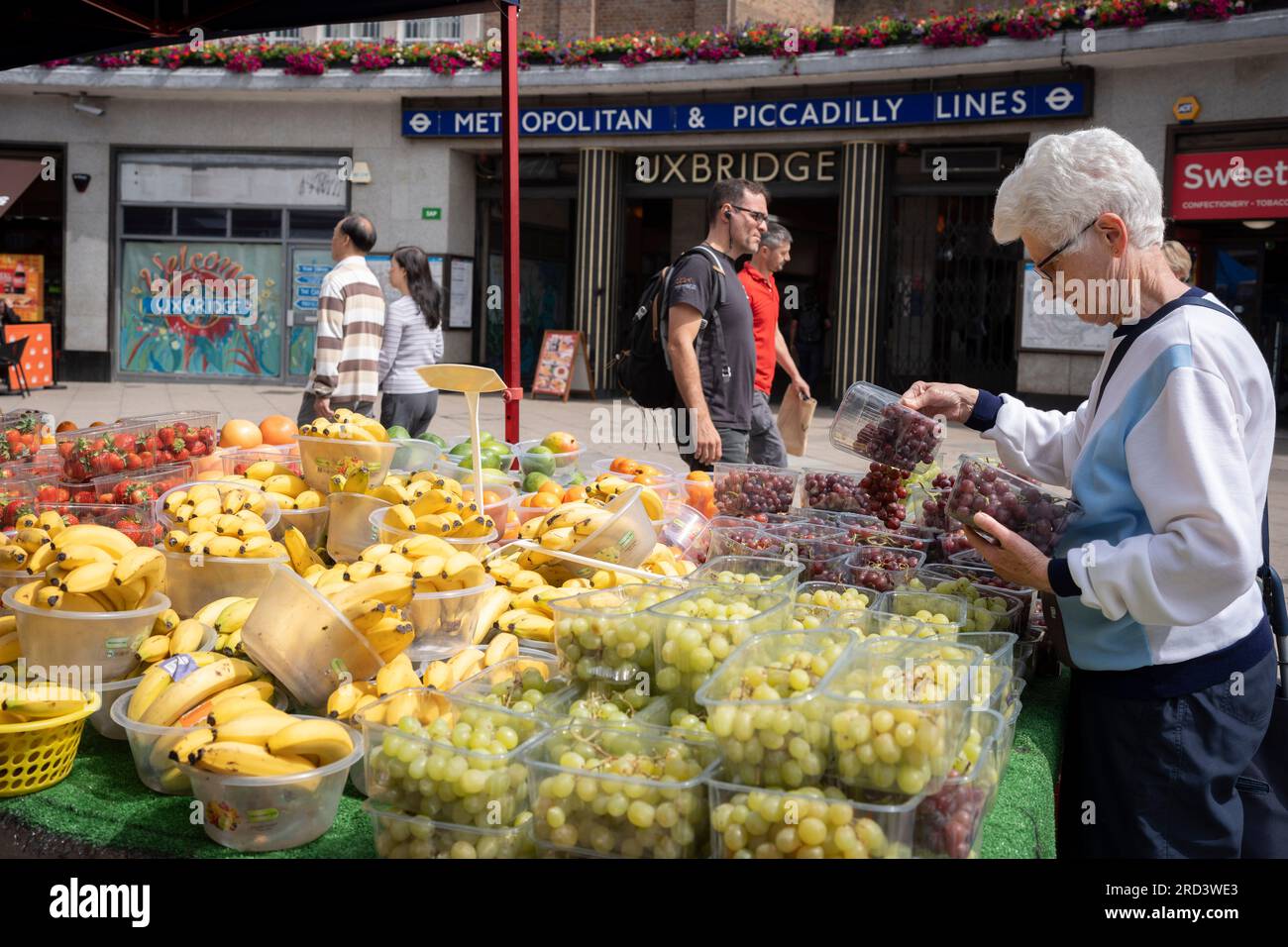 Deux jours avant l'élection partielle politique, les résidents achètent des fruits et légumes devant la station de métro Uxbridge, le 18 juillet 2023, à Londres, en Angleterre. La circonscription d'Uxbridge et de South Ruislip est l'une des trois élections partielles locales tenues le même jour, mais Uxbridge a été représentée au Parlement par l'ancien Premier ministre conservateur Boris Johnson pendant huit ans avant de démissionner de son poste de député. Il sera contesté par 17 candidats le 20 juillet. Banque D'Images