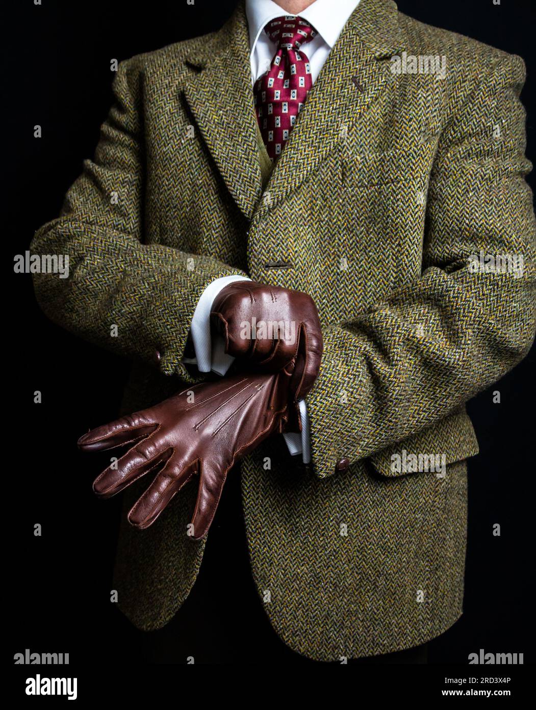 Portrait de l'homme en tweed suit tirant sur des gants en cuir. Style vintage et mode rétro de British Gentleman. Banque D'Images