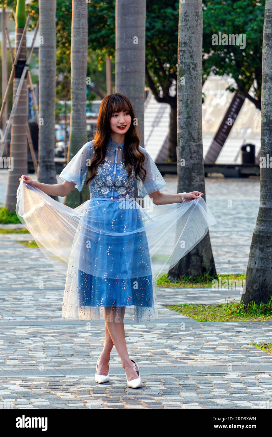 Jeune modèle féminin chinois attrayant posant pour la photo à côté des arbres à Hong Kong, SAR, Chine Banque D'Images