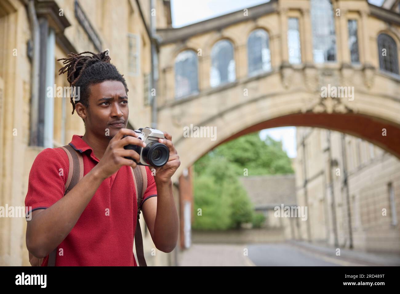 Jeune homme voyageant en vacances prendre des photos avec un appareil photo lors d'une visite à Oxford Banque D'Images