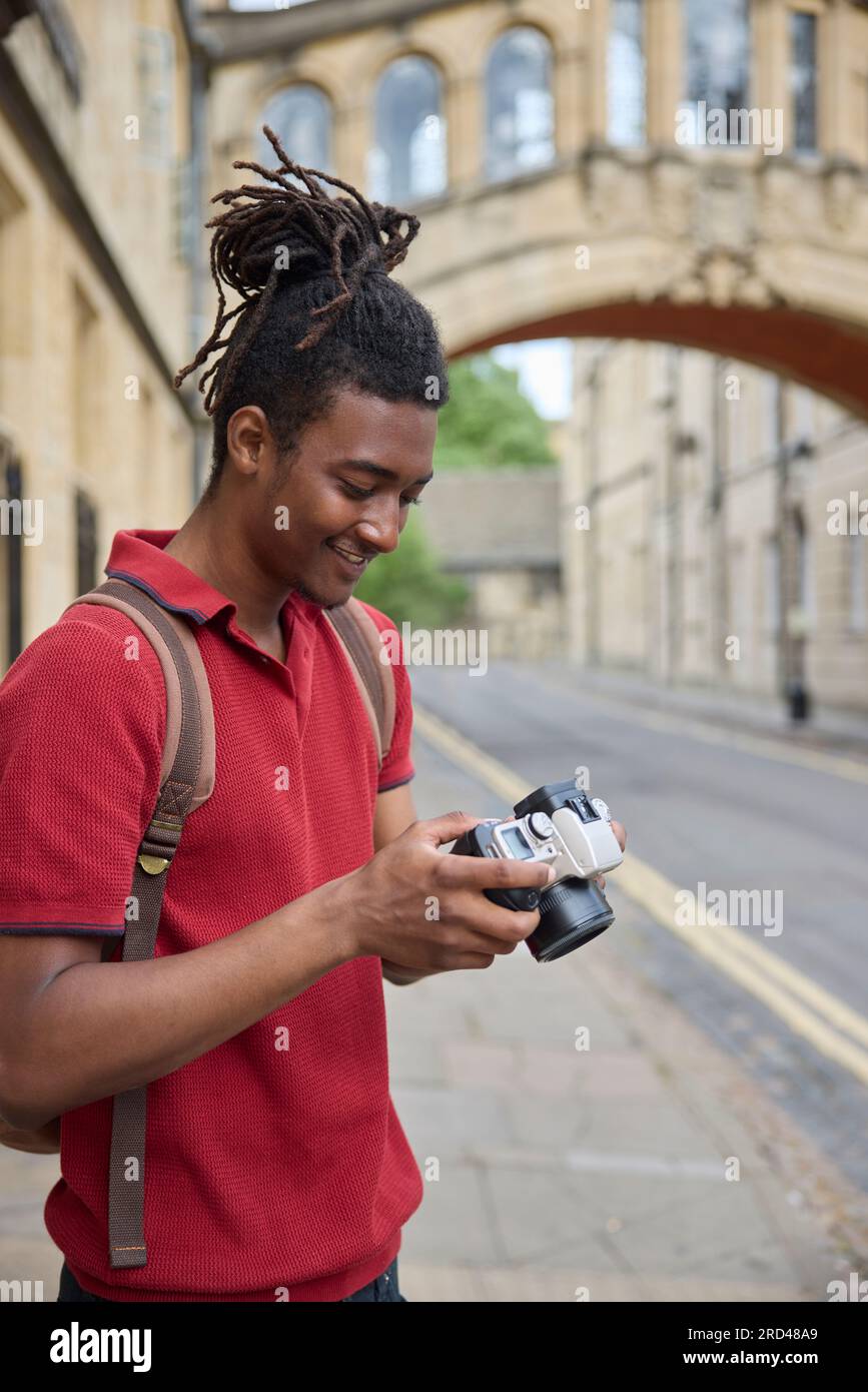 Jeune homme voyageant en vacances prendre des photos avec un appareil photo lors d'une visite à Oxford Banque D'Images