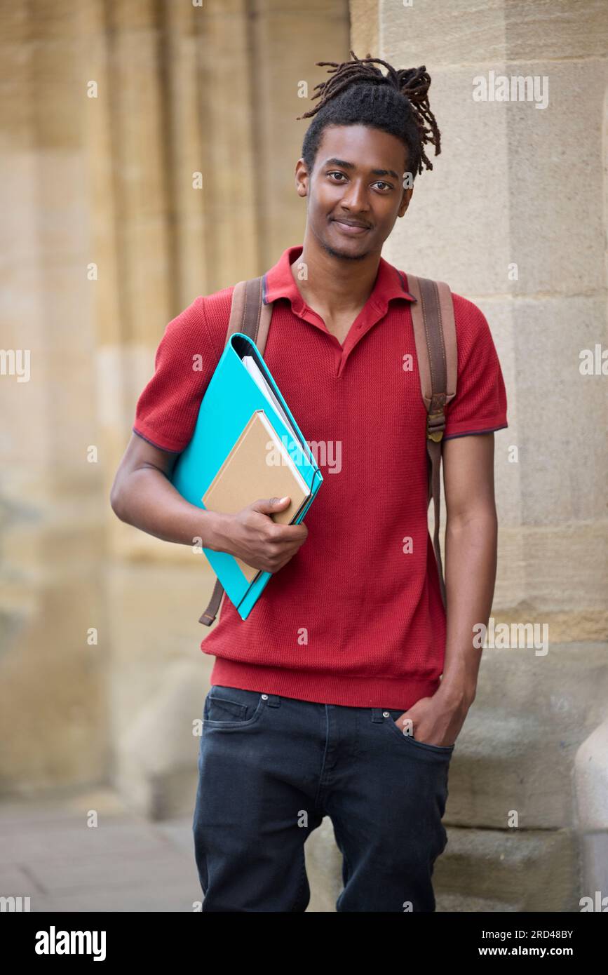 Portrait d'un étudiant portant des dossiers à l'extérieur du bâtiment de l'université d'Oxford, au Royaume-Uni Banque D'Images