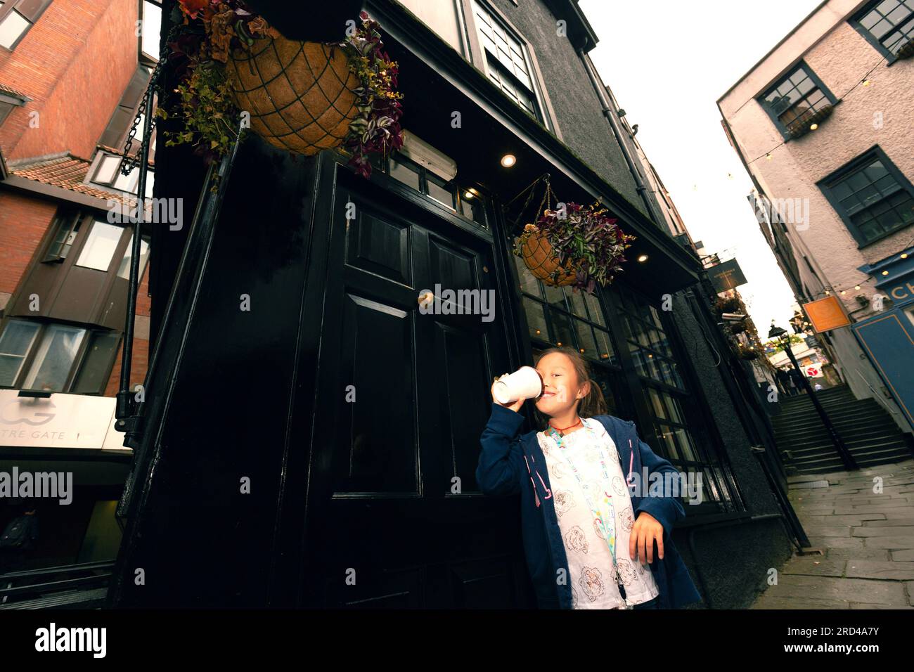 Une fille a un chocolat chaud en face de la rue historique dans la ville de Bristol, en Angleterre, célèbre monument-étapes de Noël, excursion d'une journée Bristol Banque D'Images