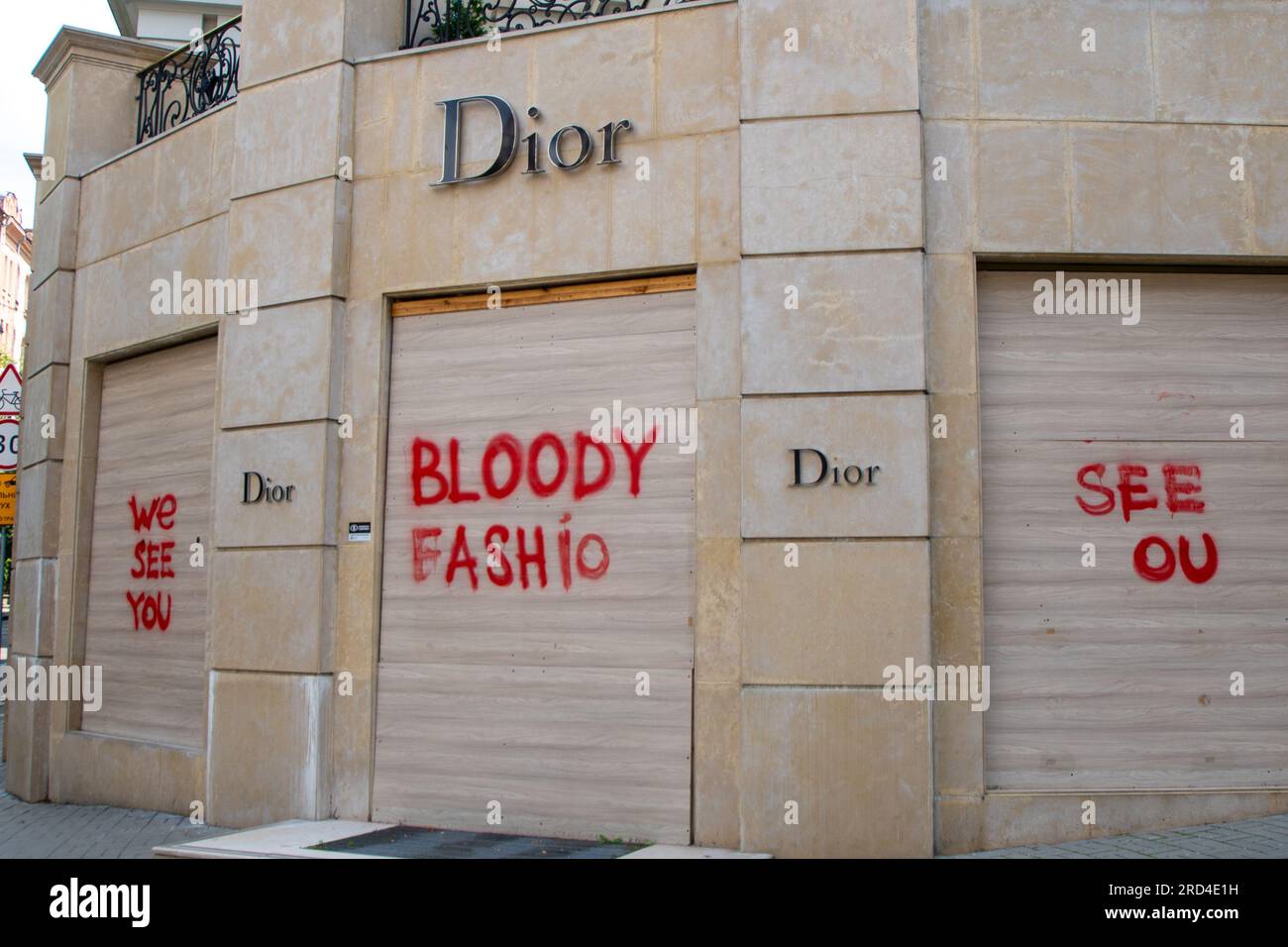Enseigne logo de la société DIOR sur le magasin. Bloody Fashon  l'inscription sur les fenêtres fini avec des planches. Peinture rouge en  aérosol sur le mur.Kyiv, Ukraine - 15 juillet 2023 Photo