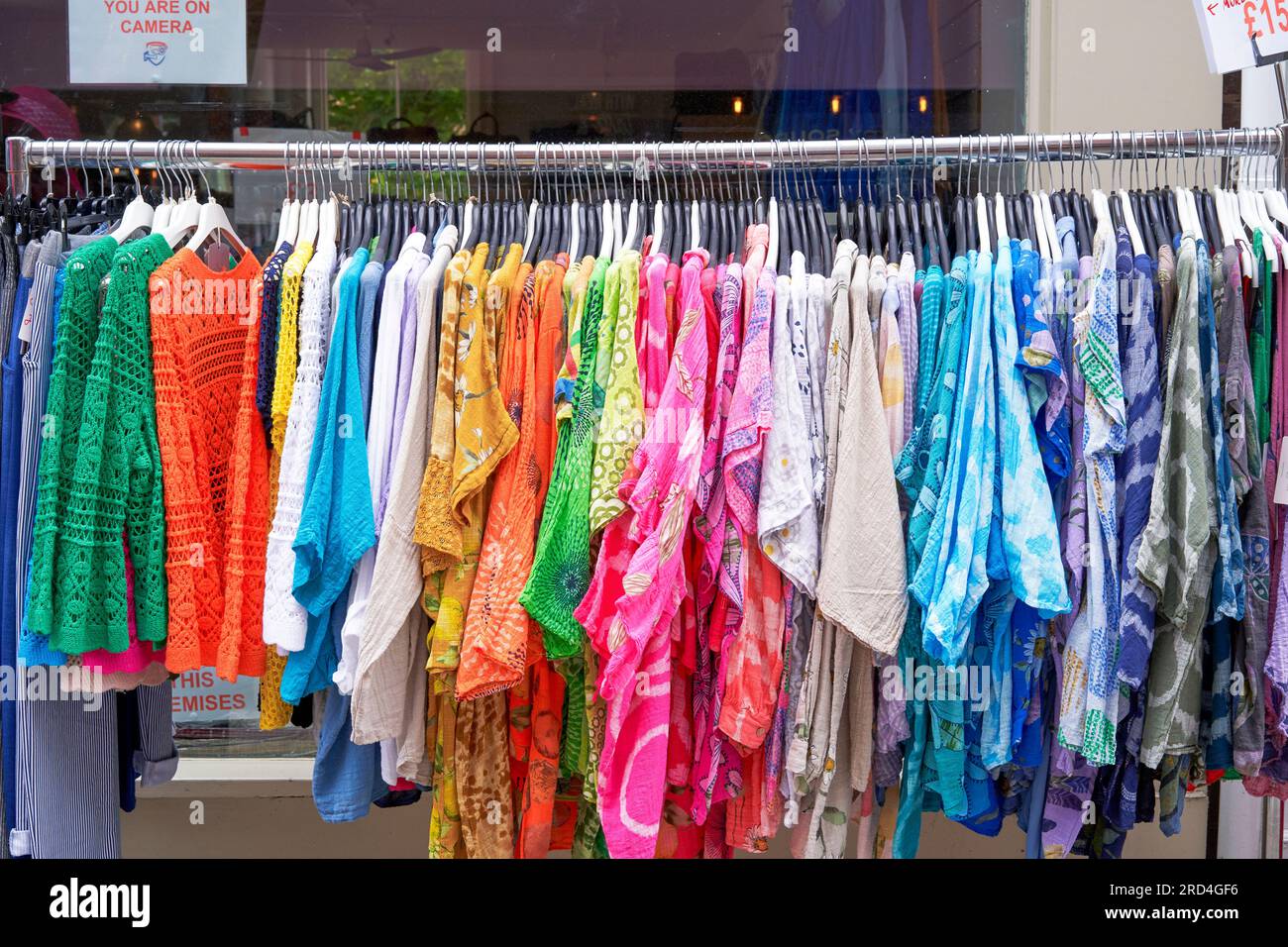Vêtements en tissu coloré suspendus sur un rail à l'extérieur d'un magasin de vêtements Banque D'Images