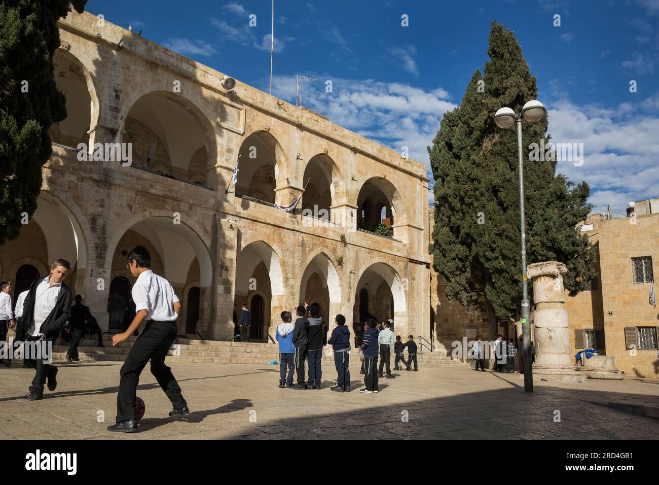 Vue horizontale de quelques enfants jouant dans la cour de récréation d'un centre éducatif séfarade dans le quartier juif, Jérusalem, Israël Banque D'Images