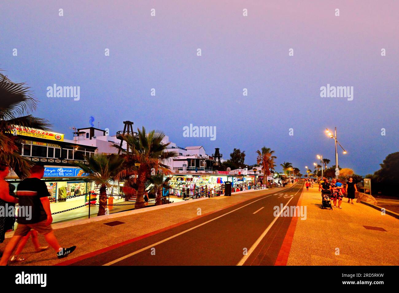 Lanzarote Îles Canaries Arrecife Matagorda la nuit illuminé cafés et palmiers avec ciel bleu du soir Banque D'Images
