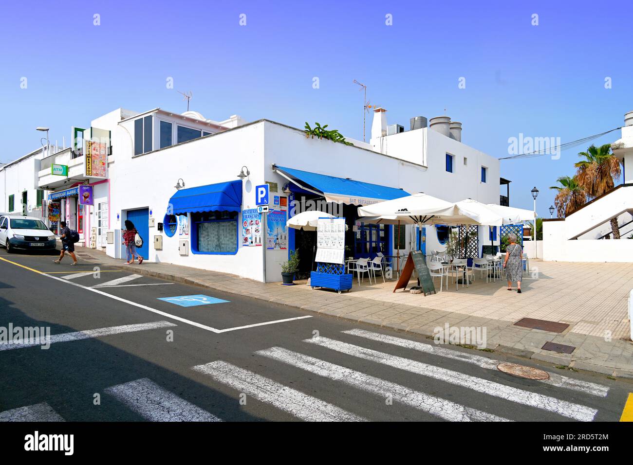 Lanzarote Îles Canaries Puerto Del Carmen le bleu et blanc Restaurant Francais café et palmiers avec ciel bleu clair Banque D'Images