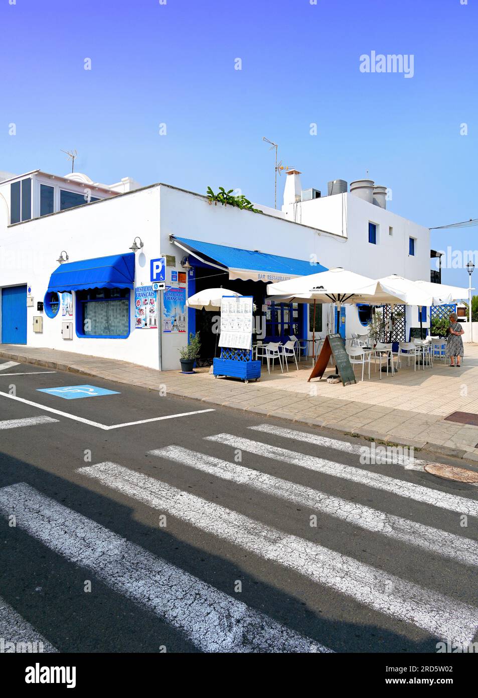 Lanzarote Îles Canaries Puerto Del Carmen le bleu et blanc Restaurant Francais café et palmiers avec ciel bleu clair Banque D'Images