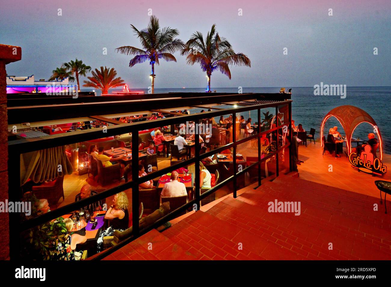 Lanzarote Îles Canaries Puerto Del Carmen le restaurant Cafe la Ola sur la rue principale donnant sur la plage et les palmiers avec bleu clair t Banque D'Images