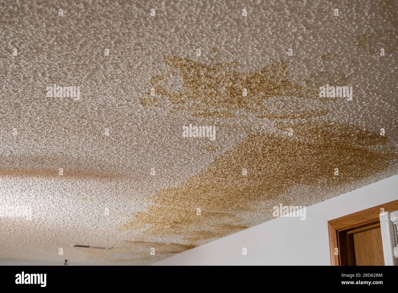 Taches d'eau sur un plafond intérieur de maison avec finition pop-corn après une fuite d'eau majeure. ÉTATS-UNIS. Banque D'Images