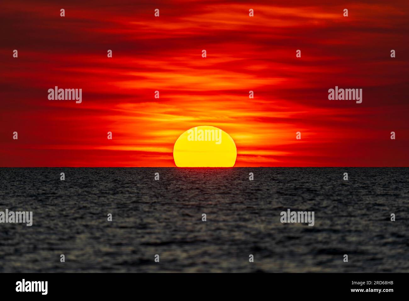 Coucher de soleil spectaculaire à l'horizon à Mindil Beach, ressemblant quelque peu au drapeau aborigène australien. Darwin, Australie. Banque D'Images