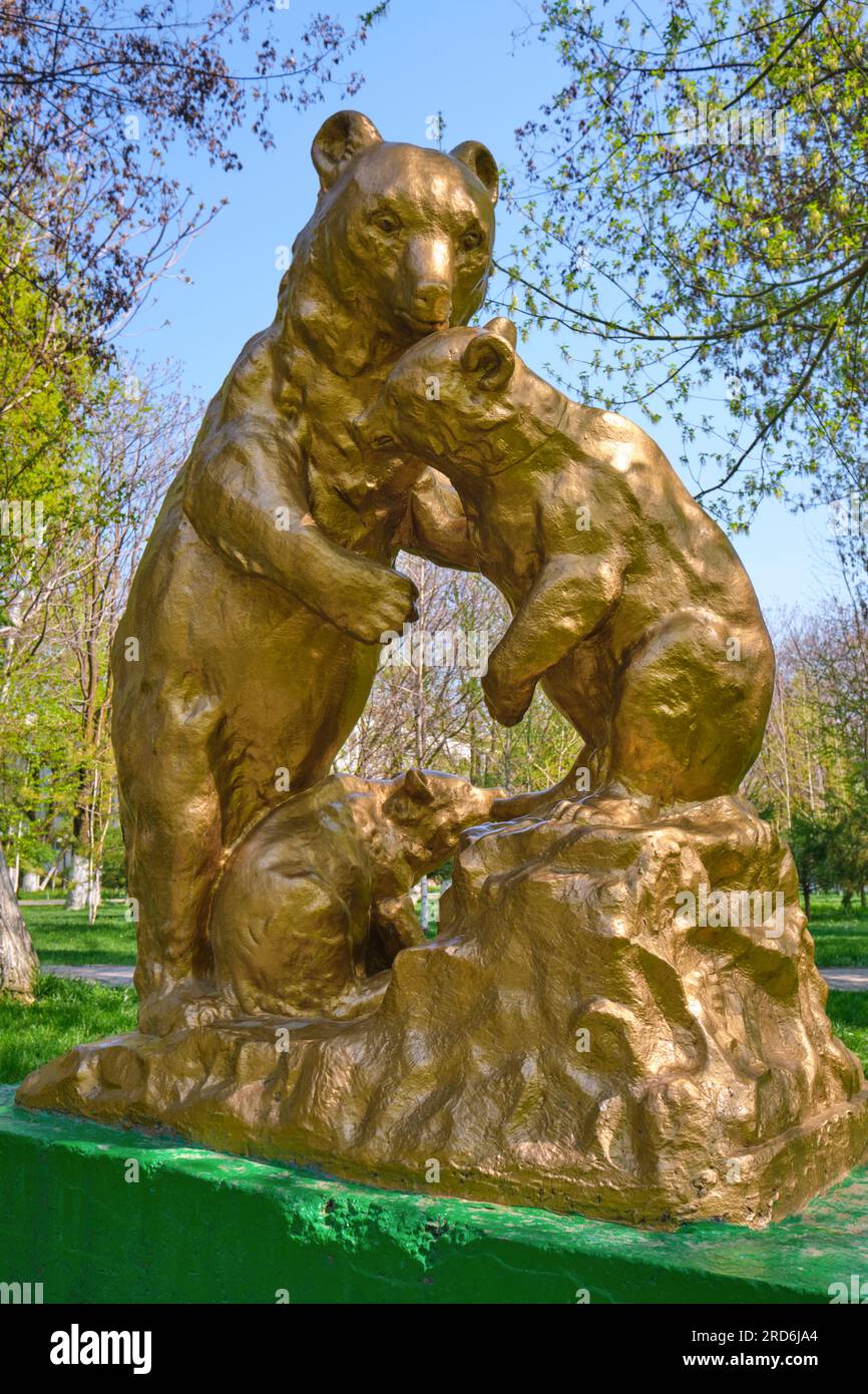 Une grande sculpture en béton, peinte en or, statue d'une mère ours et de ses petits. À Central Park à Shymkent, Kazakhstan. Banque D'Images
