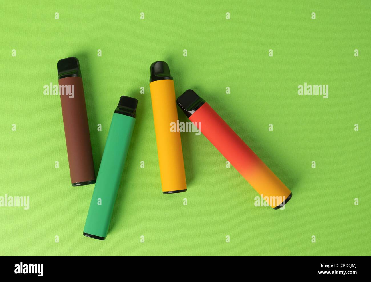 Ensemble de cigarettes électroniques jetables colorées sur un fond vert. Le concept de tabagisme moderne. Vue de dessus Banque D'Images