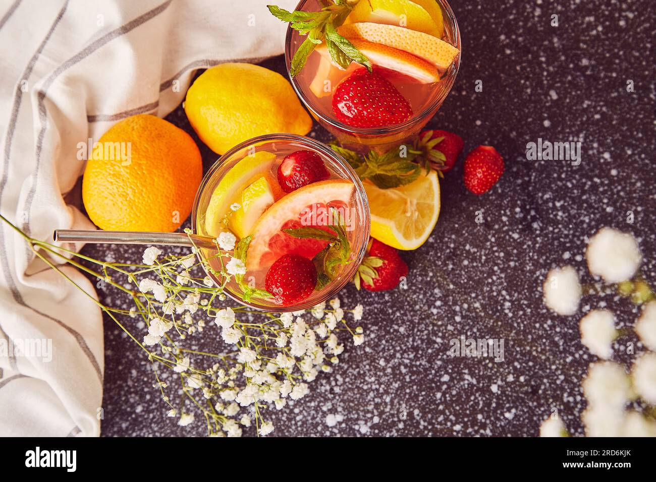 Cocktails esthétiques rafraîchissants avec agrumes et fraises. Eau détox vitaminée d'été. Les boissons à faible teneur en alcool sans résistance sont décorées de gypsophila. Banque D'Images