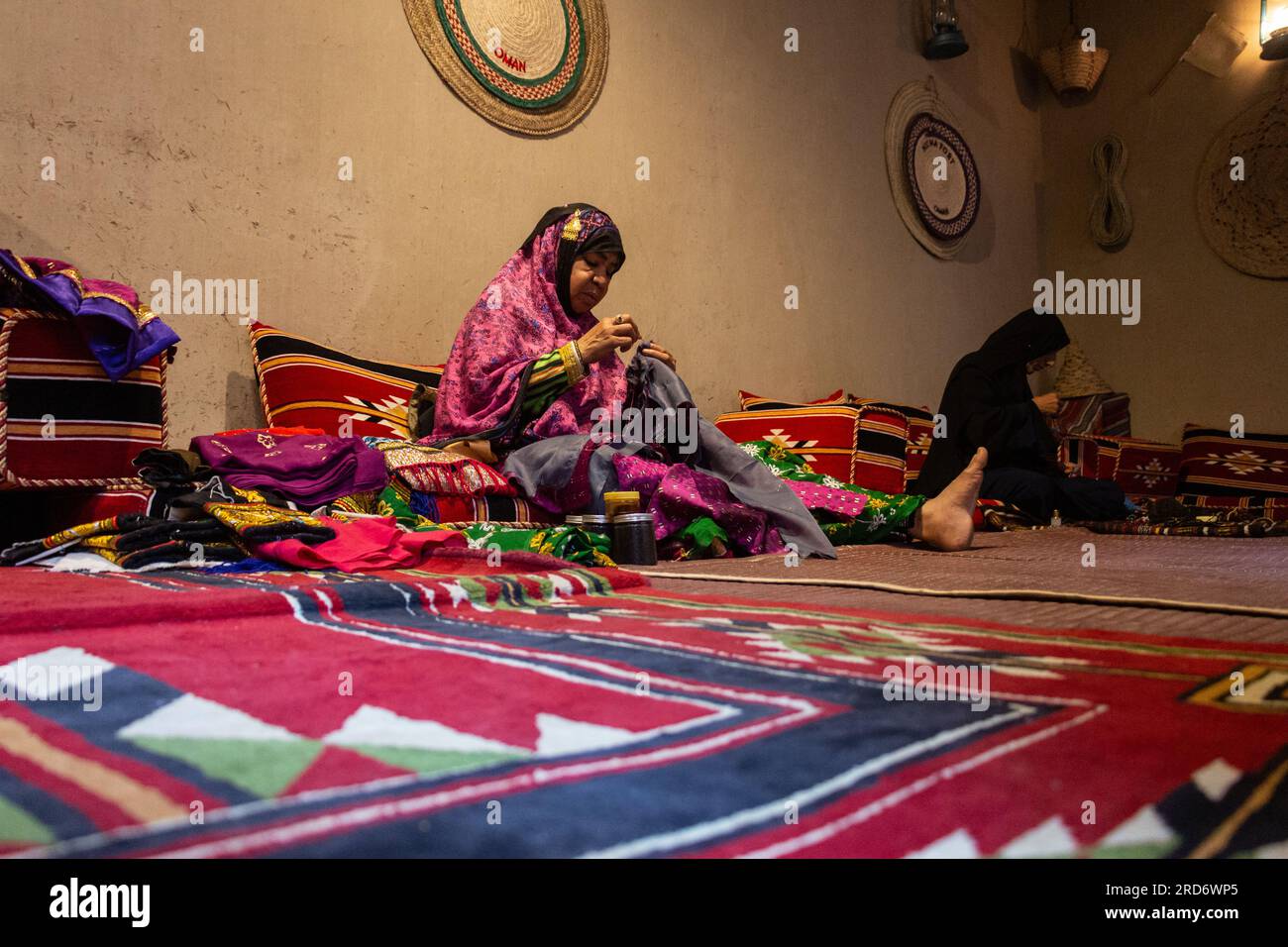 Les femmes omanaises cousent des tissus colorés au fort de Nizwa, Oman Banque D'Images