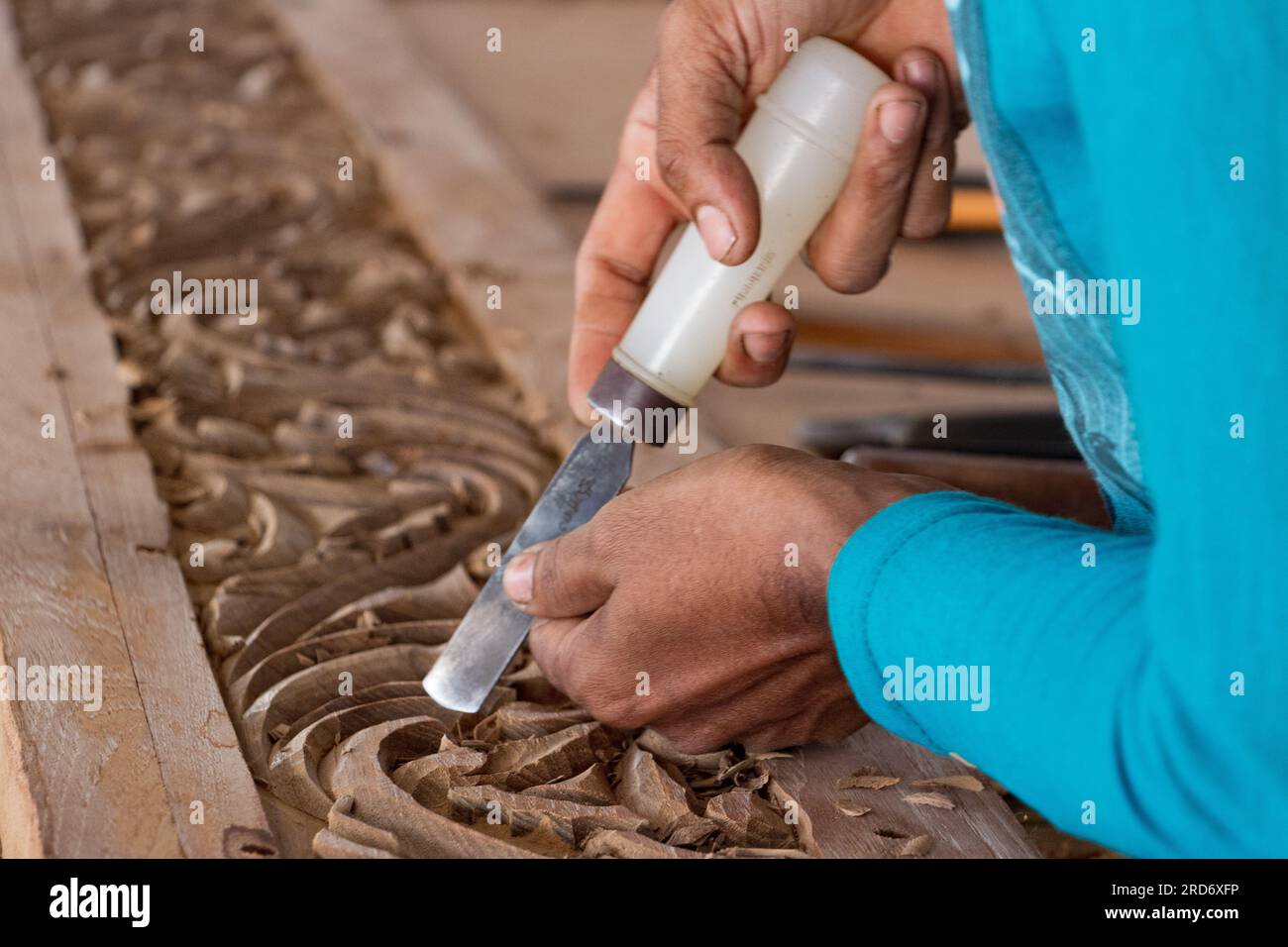 Homme travaillant sur une belle sculpture d'un boutre dans une usine de boutre à sur, Oman Banque D'Images