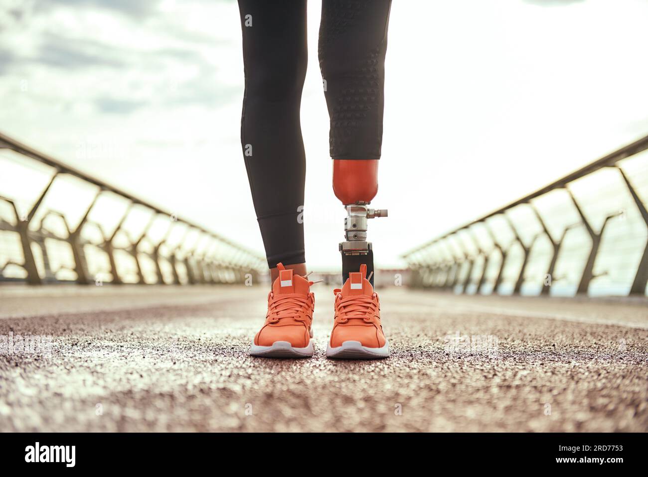 Photo recadrée d'une femme handicapée avec une prothèse de jambe en vêtements de sport debout sur le pont Banque D'Images