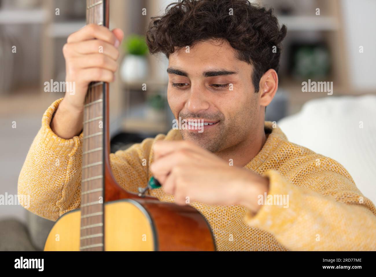 jeune homme réparateur de guitare Banque D'Images
