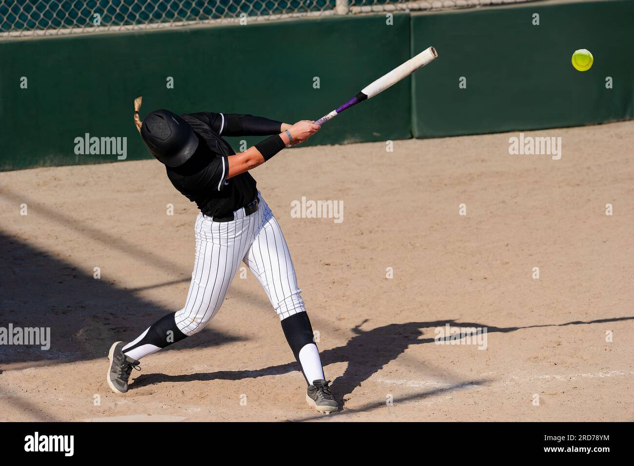 Un joueur de softball de baseball fait un pas dans le ballon Banque D'Images