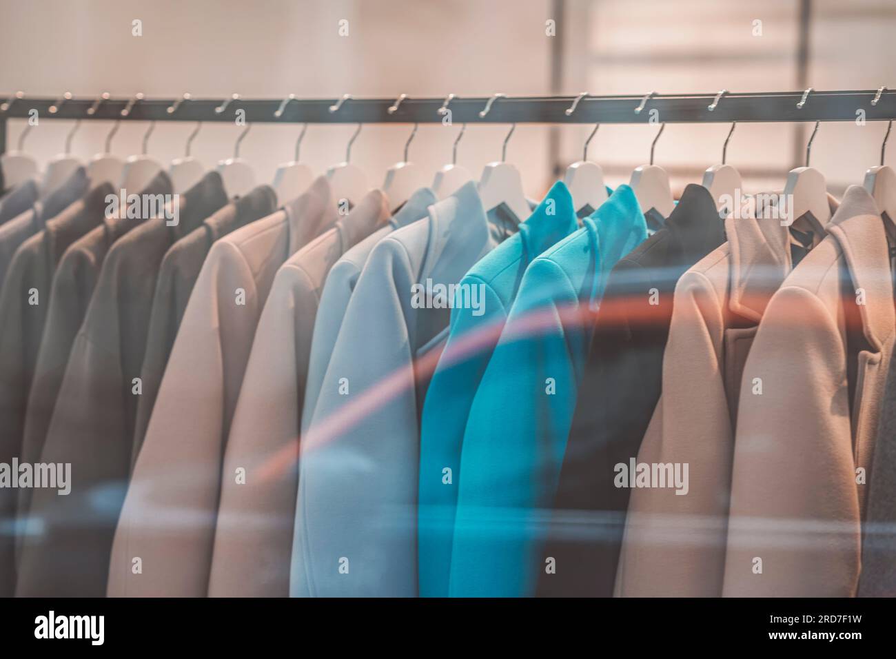 Manteaux décontractés élégants suspendus sur cintre dans le magasin de vêtements, intérieur flou du magasin. Concept de magasin, vente Banque D'Images