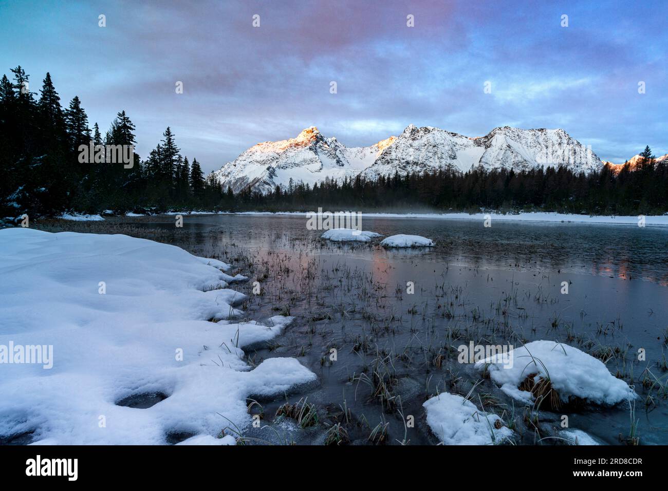 Montagnes enneigées entourant le lac gelé Entova, Valmalenco, Valtellina, Lombardie, Italie, Europe Banque D'Images