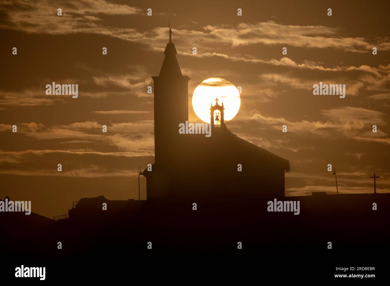 Soleil aligné avec la silhouette de l'église de Luarca, Asturies, Espagne, Europe Banque D'Images
