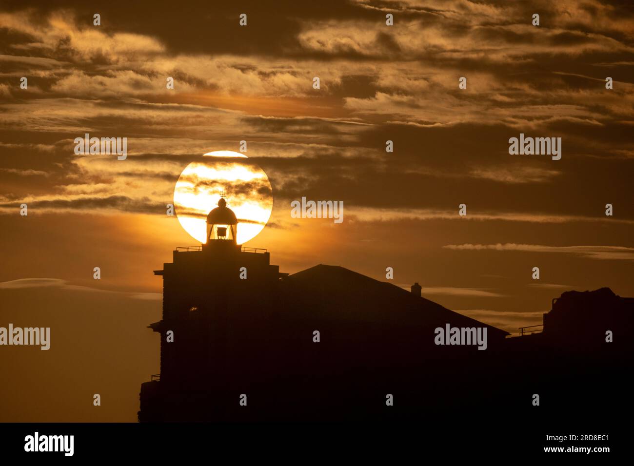 Soleil aligné avec la silhouette du phare de Luarca, Asturies, Espagne, Europe Banque D'Images