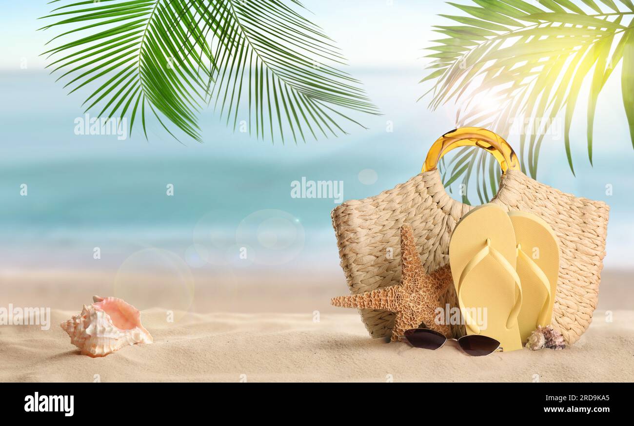 Vacances d'été. Sac avec accessoires sur la plage ensoleillée de l'océan, espace pour le texte. Conception de bannière Banque D'Images