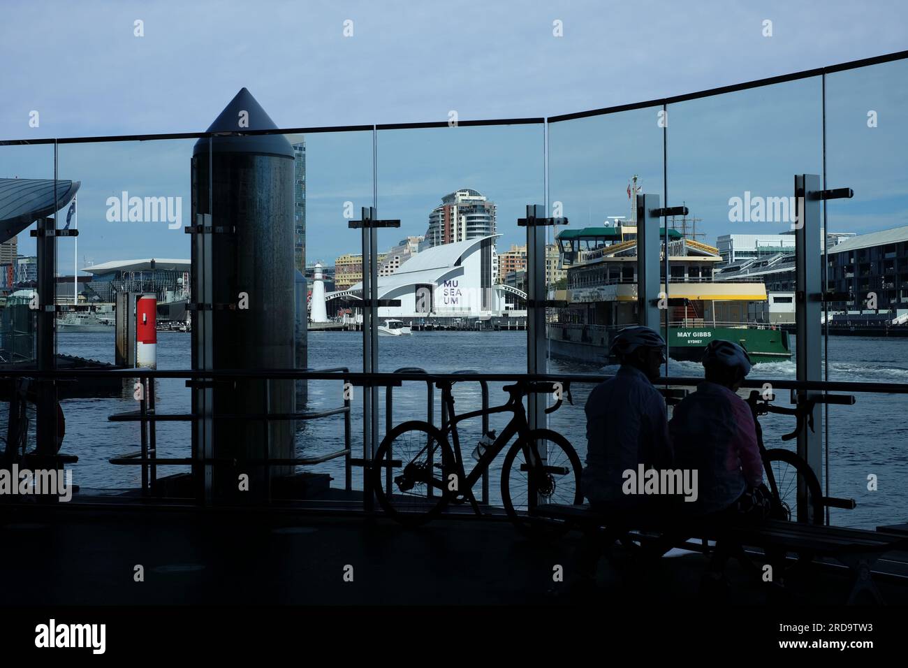 Les navetteurs regardent à travers le mur de verre sur le quai du ferry à Barangaroo Central avec Darling Harbour et Maritime Museum en arrière-plan Banque D'Images